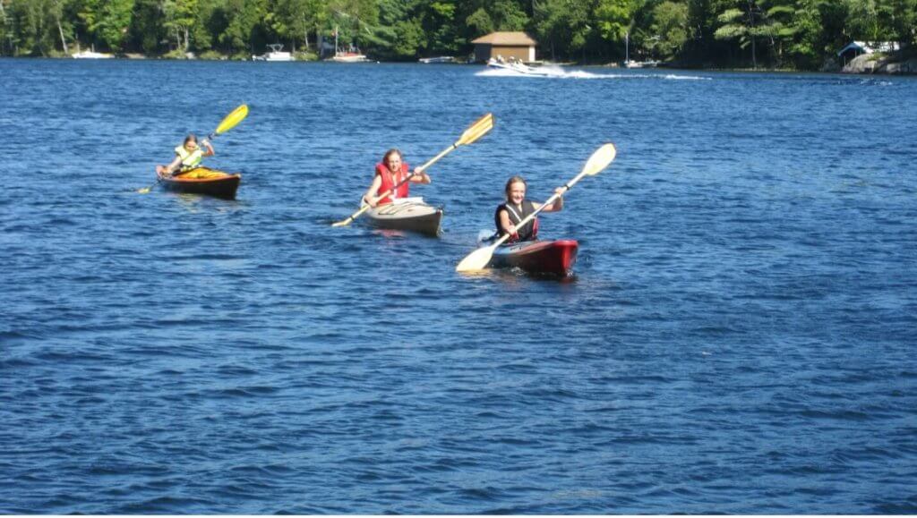 three young kayakers in open water