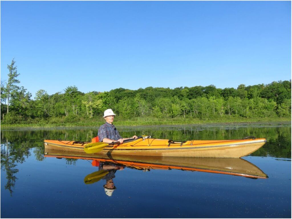 man in a kayak on calm water