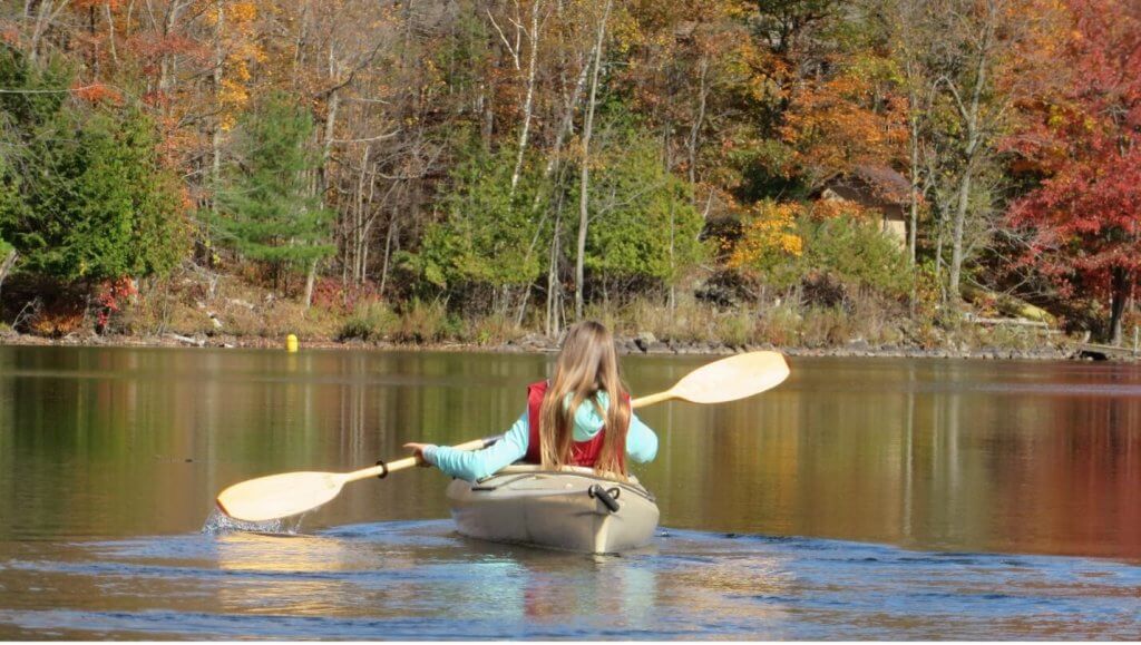 How to paddle a kayak - a young girl in a kayak paddling on a lake